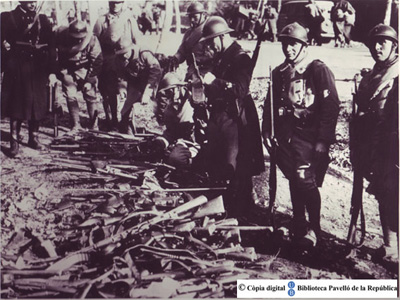 Guardia francesa ante una pila de fusiles: desarme exiliados [Fuente: UB-Biblioteca del Pavelló de la República]
